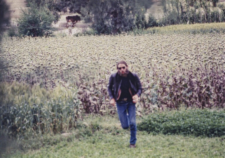 Duane running from a poppy field with souvenirs in hand